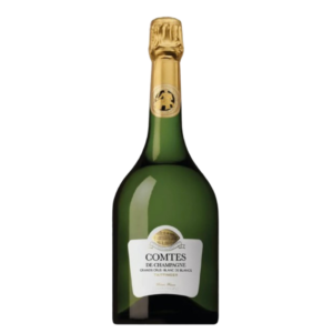 Flaske med guldetiket står oprejst. Etiketteksten siger: "COMTES DE CHAMPAGNE", "GRANDS CRUS – BLANC DE BLANCS", "TAITTINGER". Flaskehalsen er indpakket i guldfolie. Baggrund er hvid.