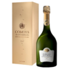 En flaske champagne står ved siden af en gylden æske. Tekst på æsken: "COMTES DE CHAMPAGNE GRANDS CRUS BLANC DE BLANCS 2007 TAITTINGER". Flasken har en lignende etiket.
