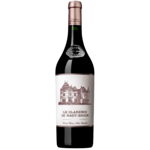 En vinflaske med etiketten "LE CLARENCE DE HAUT-BRION," viser en tegning af et hus. Flasken står i et neutralt rum.